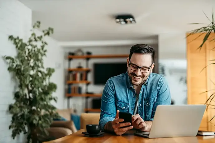 uomo sorridente con device